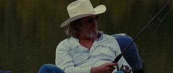 Movie still from “Crazy Heart” (2009), directed by Scott Cooper – A man in a cowboy hat is sitting in a chair; Medium shot, Over the shoulder angle