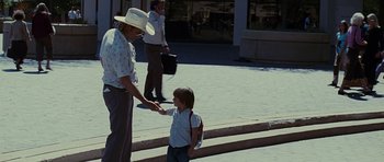 Movie still from “Crazy Heart” (2009), directed by Scott Cooper – An older woman and a young girl shaking hands on the sidewalk; Wide shot, Over the shoulder angle