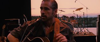 Movie still from “Crazy Heart” (2009), directed by Scott Cooper – A person holding a microphone and a guitar; Close Up shot, Over the shoulder angle