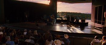 Movie still from “Crazy Heart” (2009), directed by Scott Cooper – A person on a stage in front of an audience at sunset; Extreme Wide shot, High angle