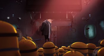 Movie still from “Despicable Me” (2010), directed by Pierre Coffin – A man in a striped scarf standing next to a group of yellow barrels; Wide shot, Low angle