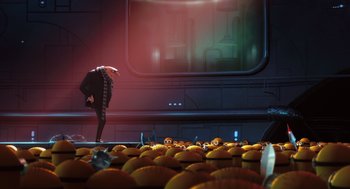 Movie still from “Despicable Me” (2010), directed by Pierre Coffin – An image of a man standing in front of a bunch of oranges; Wide shot, Low angle
