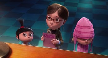 Movie still from “Despicable Me” (2010), directed by Pierre Coffin – A girl is holding a book in front of a mirror; Medium shot, Over the shoulder angle