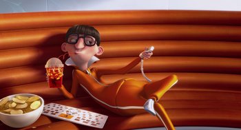 Movie still from “Despicable Me” (2010), directed by Pierre Coffin – An animated character sitting on a bench holding a wii controller; Wide shot, High angle