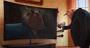 Movie still from “Despicable Me” (2010), directed by Pierre Coffin – An animated picture of an evil looking man on a tv screen; Medium shot, Low angle
