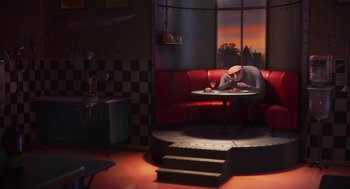 Movie still from “Despicable Me” (2010), directed by Pierre Coffin – A person sitting on a red couch in a living room; Wide shot, High angle