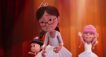 Movie still from “Despicable Me” (2010), directed by Pierre Coffin – An animated girl and a boy are standing next to each other in front of an orange curtain; Medium shot, Low angle