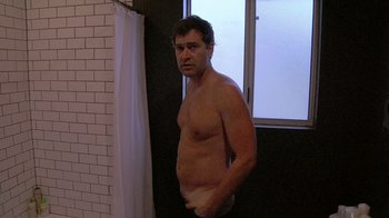 Movie still from “Creep” (2014), directed by Patrick Brice – A shirtless man in a bathroom next to a window; Medium shot, Low angle