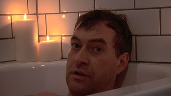 Movie still from “Creep” (2014), directed by Patrick Brice – A person sitting in a bathtub; Close Up shot, Low angle