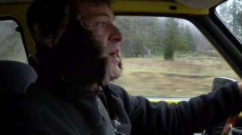 Movie still from “Creep” (2014), directed by Patrick Brice – A man with a beard driving a yellow car; Close Up shot, Over the shoulder angle