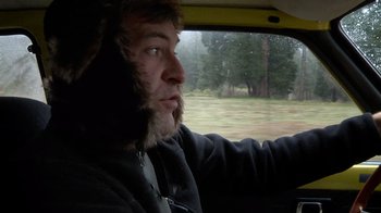 Movie still from “Creep” (2014), directed by Patrick Brice – A man with a beard sitting in the back of a car; Close Up shot, Over the shoulder angle