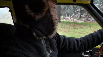 Movie still from “Creep” (2014), directed by Patrick Brice – A man wearing a fur hat driving a yellow car; Close Up shot, Over the shoulder angle