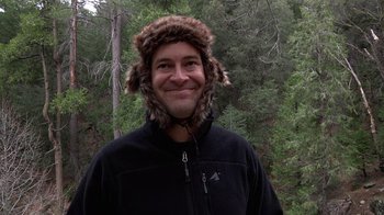 Movie still from “Creep” (2014), directed by Patrick Brice – A man wearing a fur hat standing in the woods; Close Up shot, Low angle