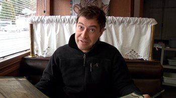 Movie still from “Creep” (2014), directed by Patrick Brice – A person sitting at a table; Close Up shot, High angle