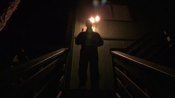 Movie still from “Creep” (2014), directed by Patrick Brice – A man standing on the stairs at night; Wide shot, Low angle
