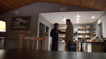 Movie still from “Creep” (2014), directed by Patrick Brice – Two men standing in a room talking to each other; Wide shot, Low angle