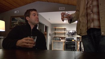 Movie still from “Creep” (2014), directed by Patrick Brice – Two men are having a drink at a bar; Medium shot, Low angle