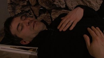 Movie still from “Creep” (2014), directed by Patrick Brice – A man laying on the ground with his hands on his chest; Close Up shot, Overhead angle
