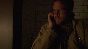 Movie still from “Creep” (2014), directed by Patrick Brice – A man with glasses talking on a cell phone; Close Up shot, Low angle