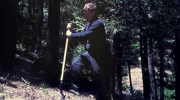 Movie still from “Creep” (2014), directed by Patrick Brice – A man in the woods holding a shovel; Wide shot, High angle