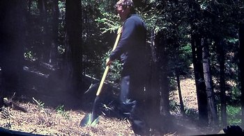 Movie still from “Creep” (2014), directed by Patrick Brice – A man with a shovel walking through the woods; Wide shot, High angle