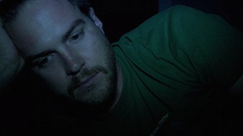Movie still from “Creep” (2014), directed by Patrick Brice – A person laying on the ground in the dark; Close Up shot, Overhead angle
