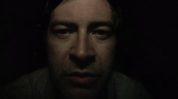 Movie still from “Creep” (2014), directed by Patrick Brice – A person's face in the dark; Extreme Close Up shot, Low angle