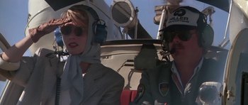 A man and a woman are in a helicopter cockpit