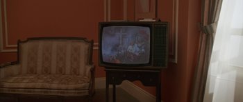 An old television set in a living room with a chair