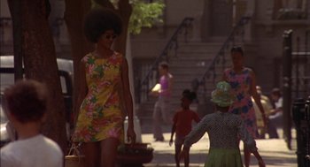 Movie still from “Crooklyn” (1994), directed by Spike Lee – A woman walking down a street with a basket; Wide shot, Low angle