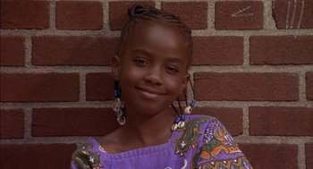 Movie still from “Crooklyn” (1994), directed by Spike Lee – A young girl wearing a purple shirt and a pair of dangling earrings; Close Up shot, High angle