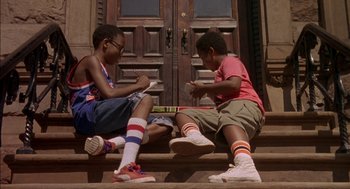 Movie still from “Crooklyn” (1994), directed by Spike Lee – Two young boys sitting on the steps of a house; Wide shot, Low angle