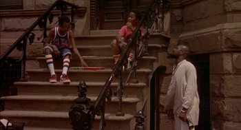 Movie still from “Crooklyn” (1994), directed by Spike Lee – Two young boys sitting on the steps of an old building; Wide shot, High angle
