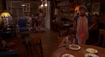 Movie still from “Crooklyn” (1994), directed by Spike Lee – A young boy eating cake at a dining room table; Wide shot, High angle