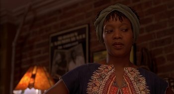 Movie still from “Crooklyn” (1994), directed by Spike Lee – A woman wearing a head scarf standing in front of a brick wall; Close Up shot, Low angle