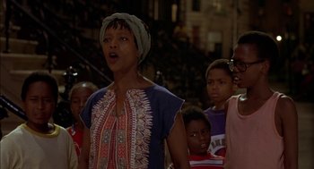 Movie still from “Crooklyn” (1994), directed by Spike Lee – A group of people standing in the street at night; Medium shot, Low angle