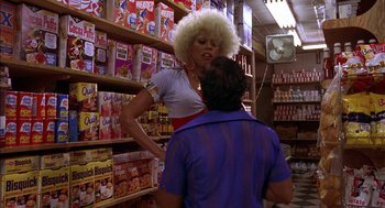 Movie still from “Crooklyn” (1994), directed by Spike Lee – A woman in a wig talking to a man in a store; Medium shot, Low angle