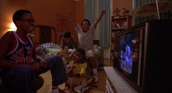 Movie still from “Crooklyn” (1994), directed by Spike Lee – A group of people sitting in a living room watching television; Wide shot, High angle
