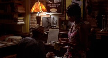 Movie still from “Crooklyn” (1994), directed by Spike Lee – A man and a woman are playing music at a piano; Medium shot, Over the shoulder angle