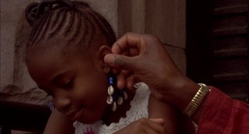 Movie still from “Crooklyn” (1994), directed by Spike Lee – A woman putting a pair of earrings on a child's ear; Close Up shot, Over the shoulder angle