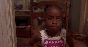 Movie still from “Crooklyn” (1994), directed by Spike Lee – A little girl sitting in a chair wearing a crocheted top; Close Up shot, Low angle