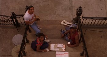 Movie still from “Crooklyn” (1994), directed by Spike Lee – A group of young people sitting on the ground; Wide shot, High angle