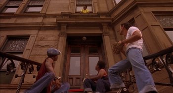 Movie still from “Crooklyn” (1994), directed by Spike Lee – A group of young men sitting on the steps of a building; Wide shot, Low angle