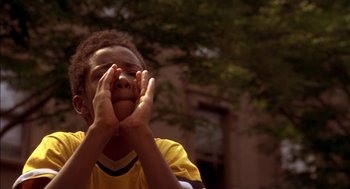 Movie still from “Crooklyn” (1994), directed by Spike Lee – A young boy holding his hands up to his face; Close Up shot, Low angle