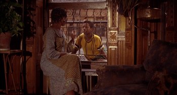 Movie still from “Crooklyn” (1994), directed by Spike Lee – A man and a woman are sitting at a table; Medium shot, Over the shoulder angle