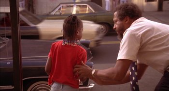 Movie still from “Crooklyn” (1994), directed by Spike Lee – A man and a girl are standing on the street; Medium shot, Low angle