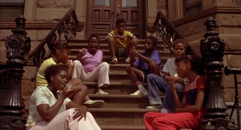 Movie still from “Crooklyn” (1994), directed by Spike Lee – A group of people sitting on the steps of a building; Wide shot, High angle