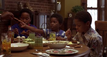 Movie still from “Crooklyn” (1994), directed by Spike Lee – A group of children sitting at a table eating food; Medium shot, High angle