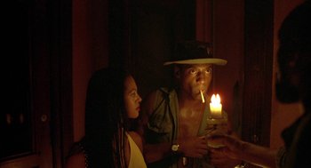 Movie still from “Crooklyn” (1994), directed by Spike Lee – A man lighting a candle next to a woman; Medium shot, Low angle