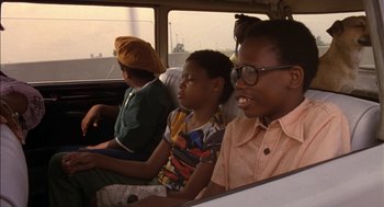 Movie still from “Crooklyn” (1994), directed by Spike Lee – A group of people sitting in a vehicle; Close Up shot, High angle